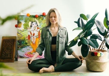 Mujer practicando yoga en casa.