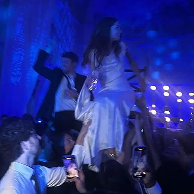 Los novios, paseados en sillas por los invitados.