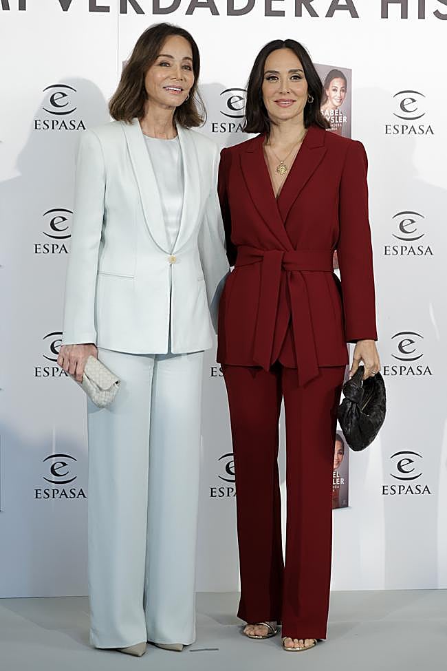 Isabel, con un traje blanco, y Tamara, con un traje rojo.