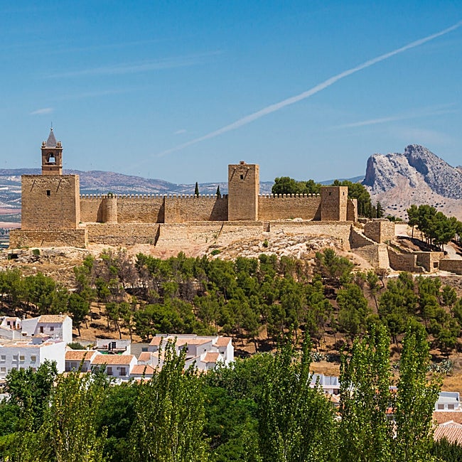 La alcazaba coronando la ciudad blanca con el Peñón de los Enamorados asomando.
