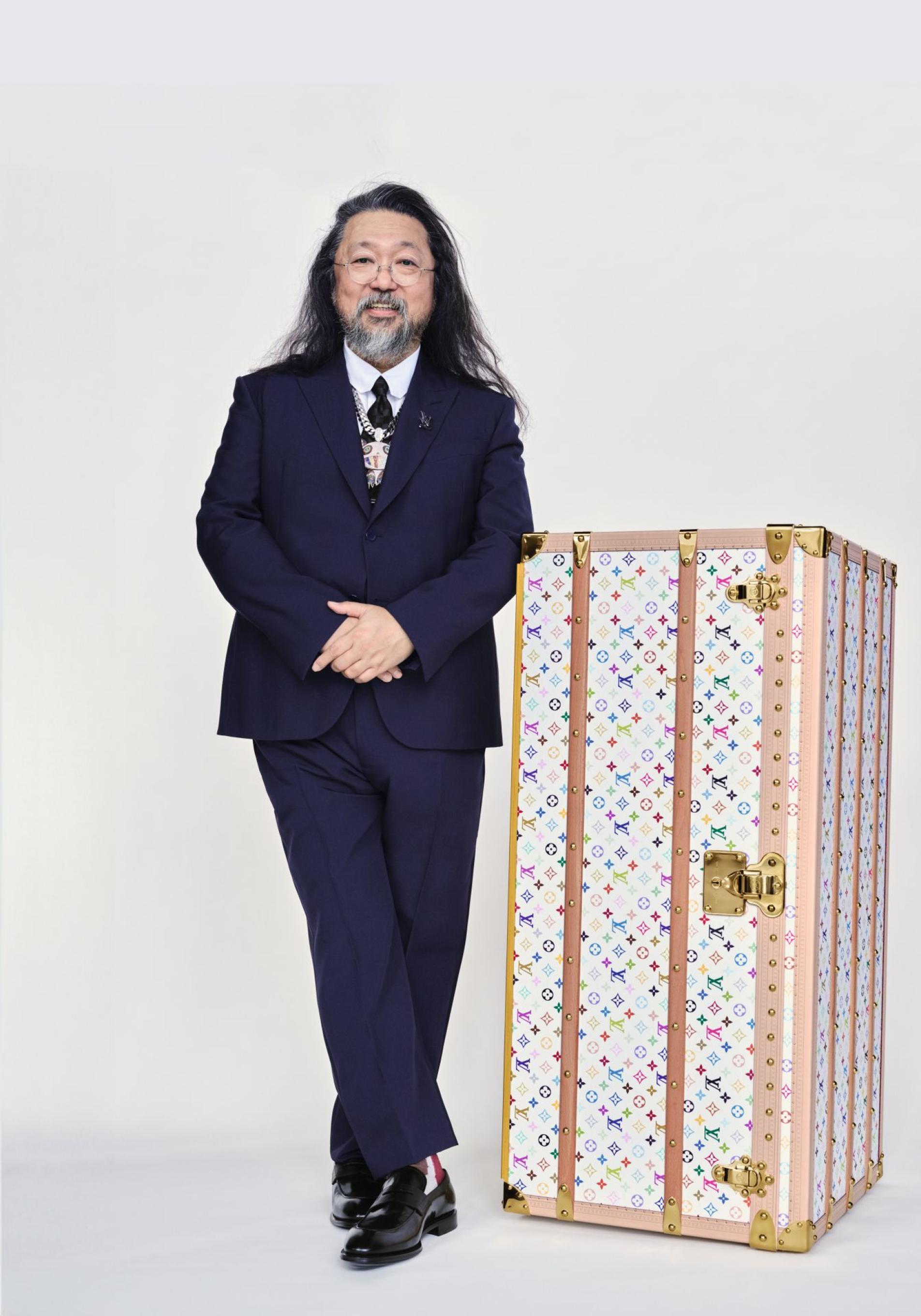 El artista japonés Takashi Murakami posa con el baúl armario Malle Wardrobe.