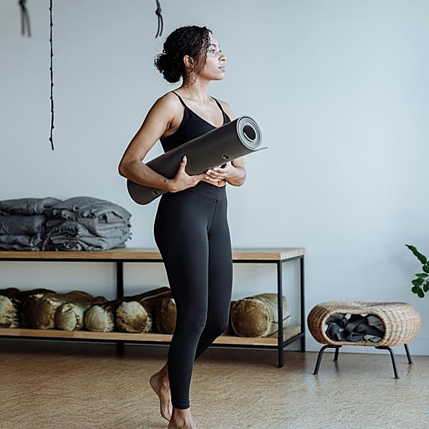 Mujer practicando Pilates con esterilla. 