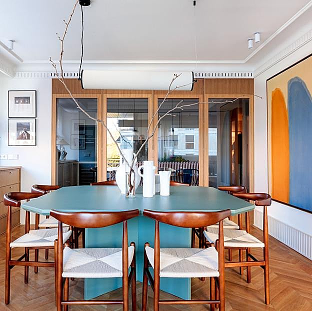 Comedor presidido por una mesa octogonal lacada en verde mate, bajo una lámpara con pantalla cilíndrica de lino, ambos, de Pilsferrer Casa. A su izda., alacena de roble natural sobre la que reposan una lámpara de Can Betelgeuse y un cesto comprado en Marruecos.