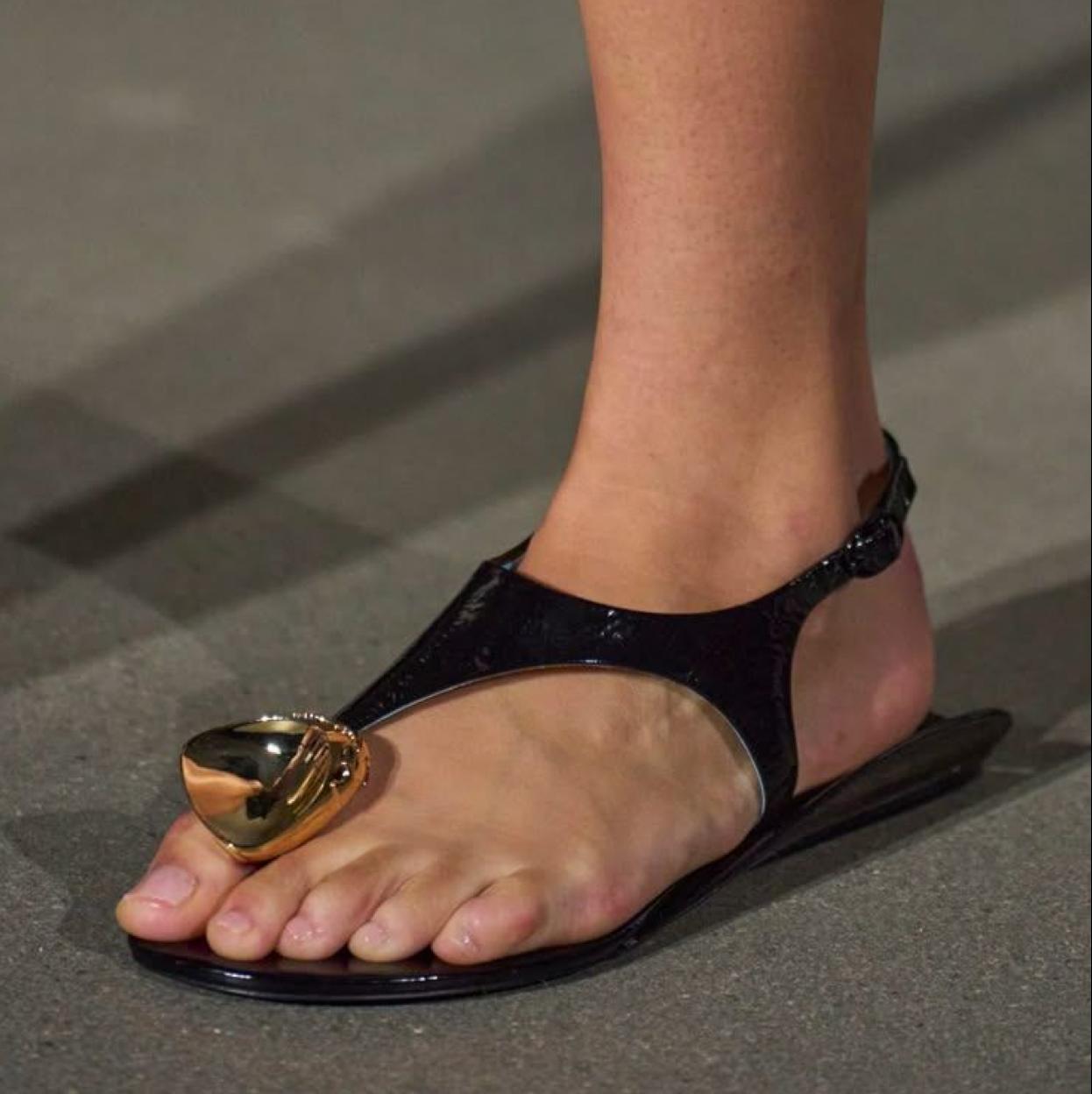 Sandalias con adorno dorado en la pasarela