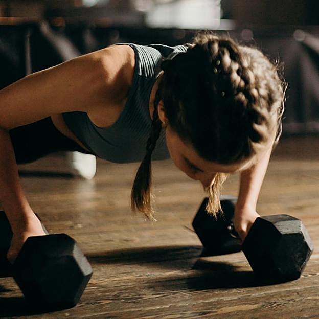 Mujer haciendo ejercicios con mancuernas. 