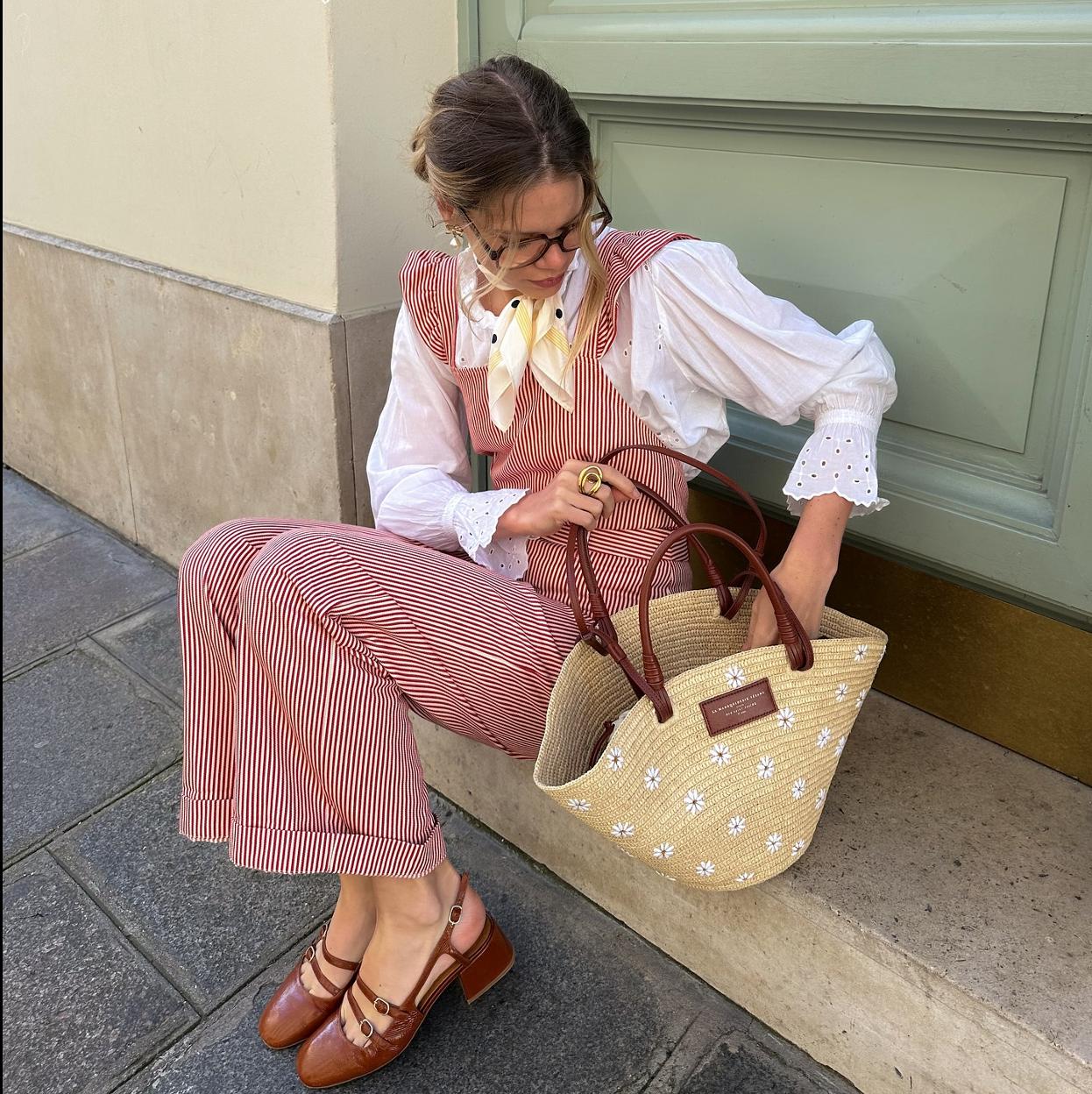 Una influencer con un bolso de rafia de Sézane.