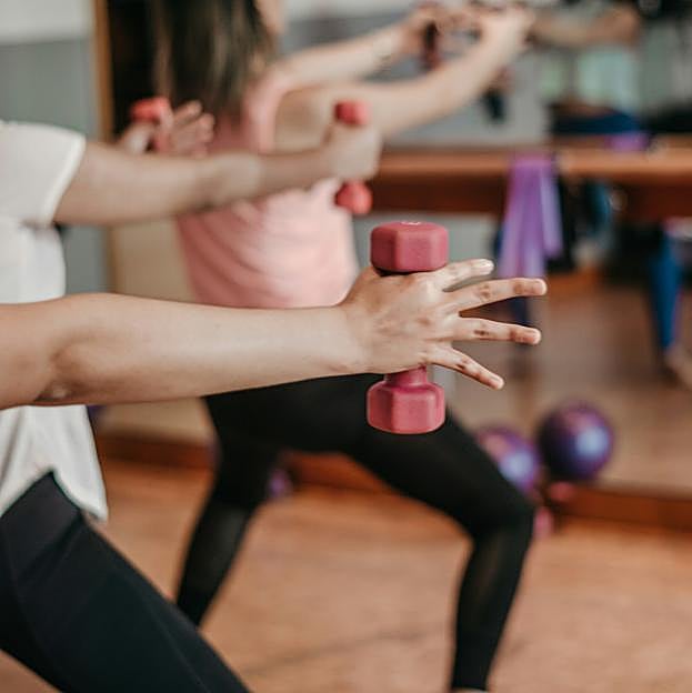 Mujeres haciendo ejercicio con mancuernas. 