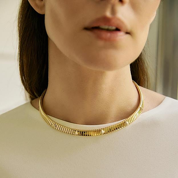 Collar Tubogas, en oro amarillo con tachuelas de pavé de diamantes, y pulsera a juego, ambos de Bvlgari. Vestido Drew Écru de Alex Rivière.