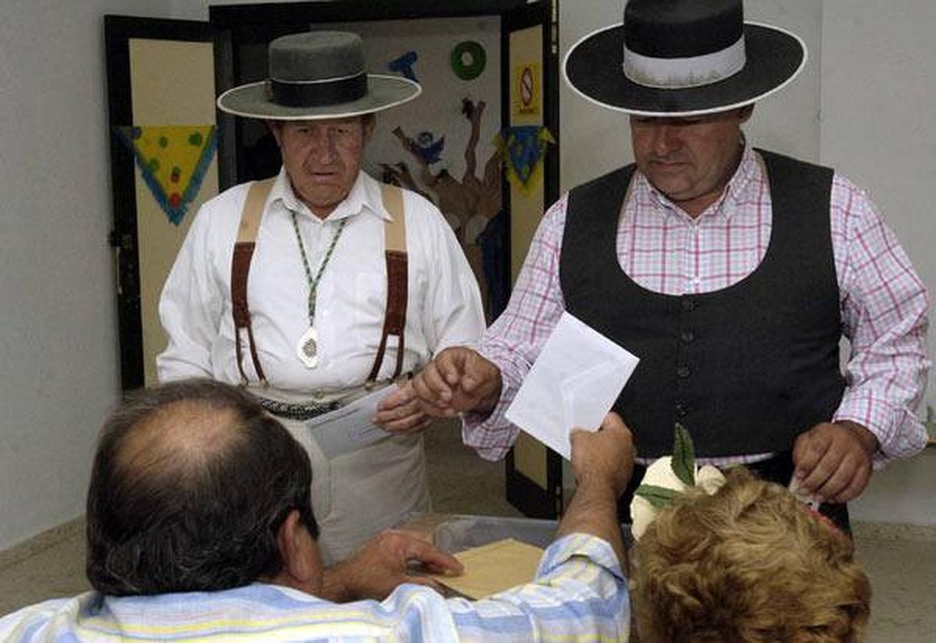 De romería electoral. Unos peregrinos depositan su voto vestidos con los trajes típicos típicos de la romería en El Rocío, Huelva.