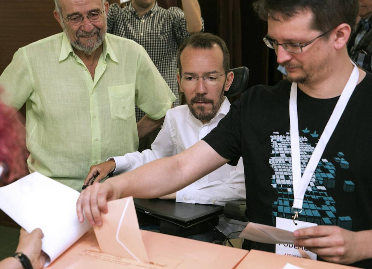 Un apoderado de Unidos Podemos (d) introduce el voto del secretario de Organización de Podemos, Pablo Echenique.