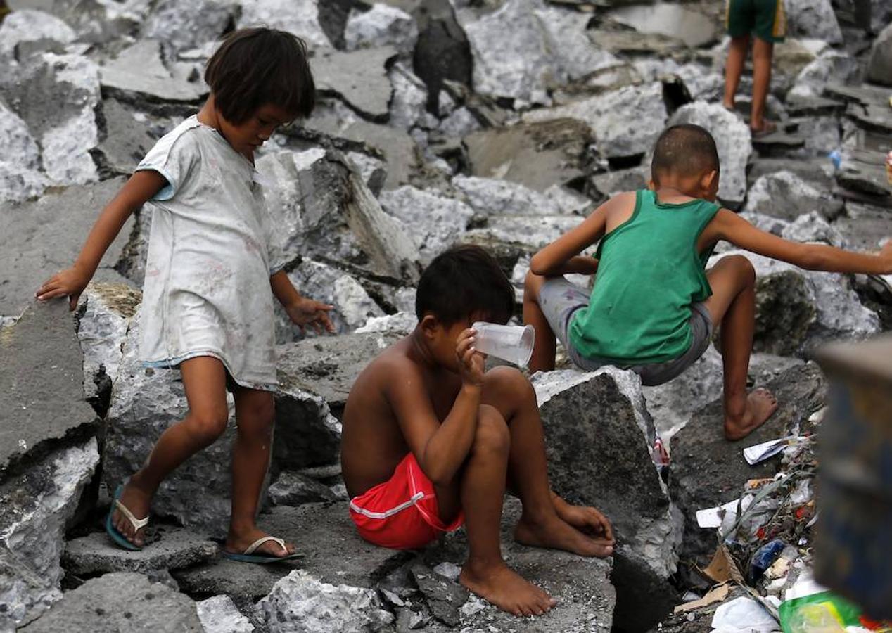 Varios niños filipinos que recogen metal en una zona de chabolas en Manila, Filipinas