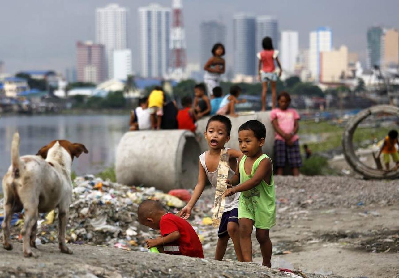 Varios niños filipinos que juegan en una zona de chabolas en Manila, Filipinas.