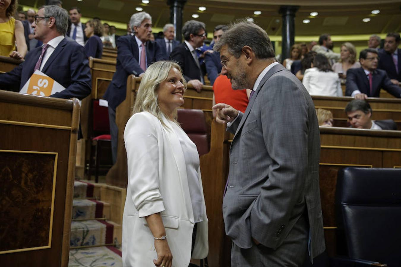 El ministro de Justicia, Rafael Catalá (d), conversa con la diputada del PP María del Mar Blanco (i), en la primera jorada del debate de investidura.