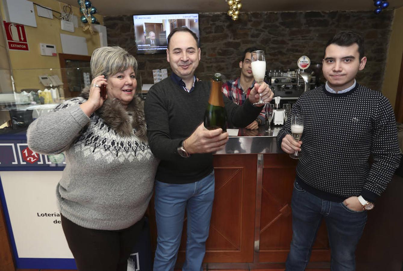 José Luis Alvarez (c) acompañado por amigos y clientes del Bar Posada del Teniente en Toral de los Vados (León) celebra el reparto de un décimo del 95379 agraciado con el segundo premio.