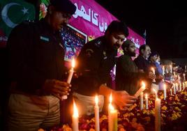 Oficiales de policía y residentes encienden velas para rendir homenaje a las víctimas del ataque suicida en la mezquita de Peshawar