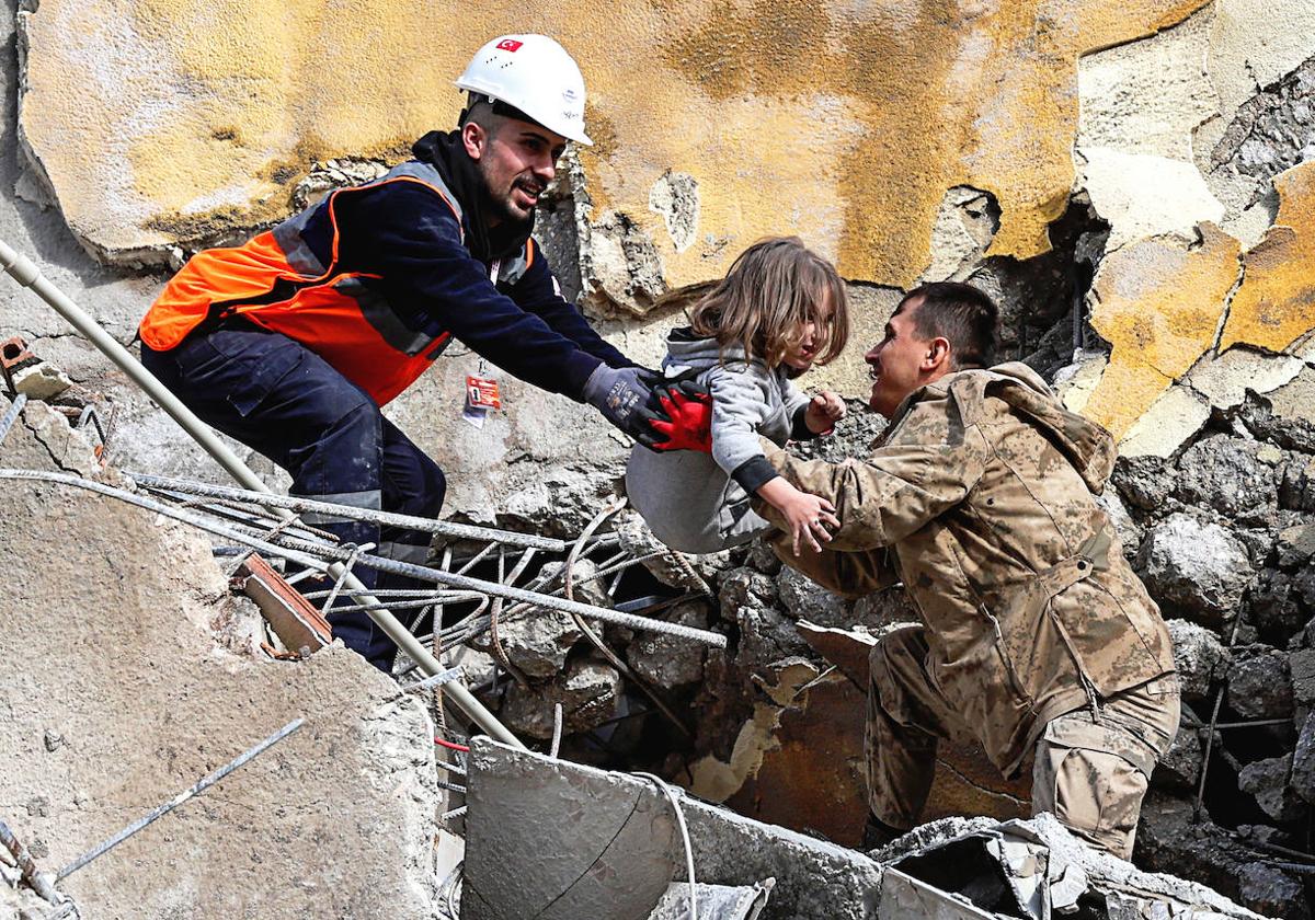 Los servicios de rescate y voluntarios ayudan a evacuar a uno de los afectados.