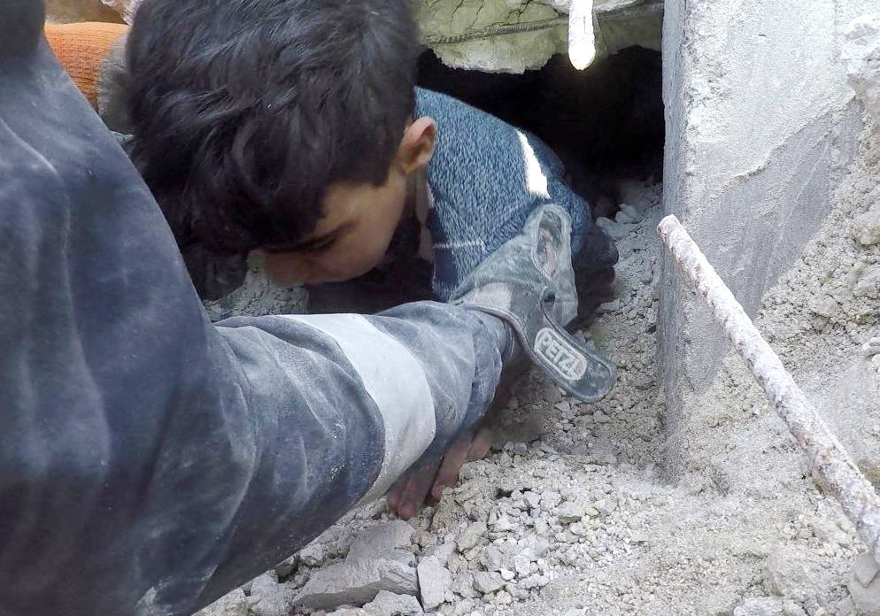 Un niño es rescatado en el lugar de un edificio dañado mientras continúa la búsqueda de supervivientes, tras el terremoto en Al Atareb, Siria. / CASCOS BLANCOS