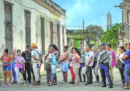 Una fila de cubanos siguen los trabajos de reparación de los daños ocasionados por el huracán 'Ian' en la localidad de El Cerro.