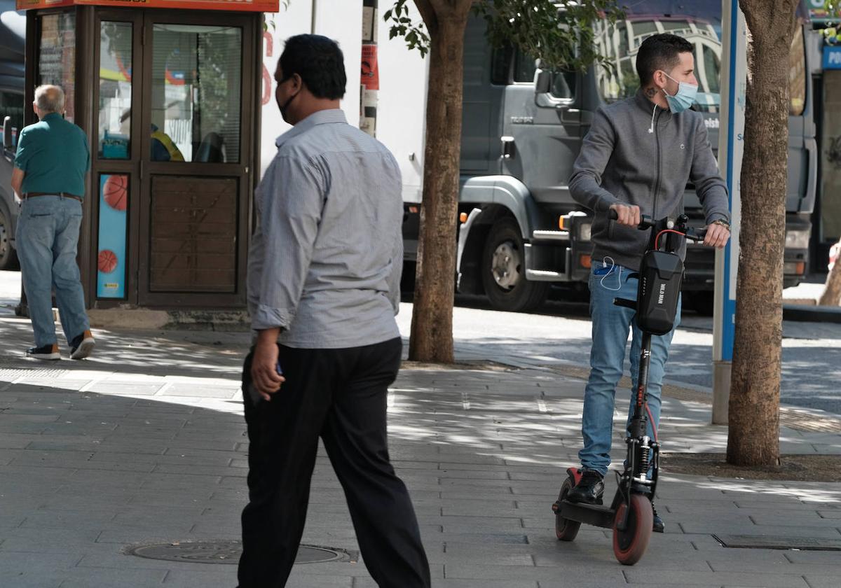 Un patinete circula por la acera.