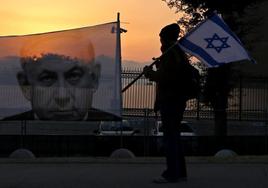 Un manifestante camina frente a un retrato del primer ministro israelí, Benyamin Netanyahu, en una calle de Jerusalén