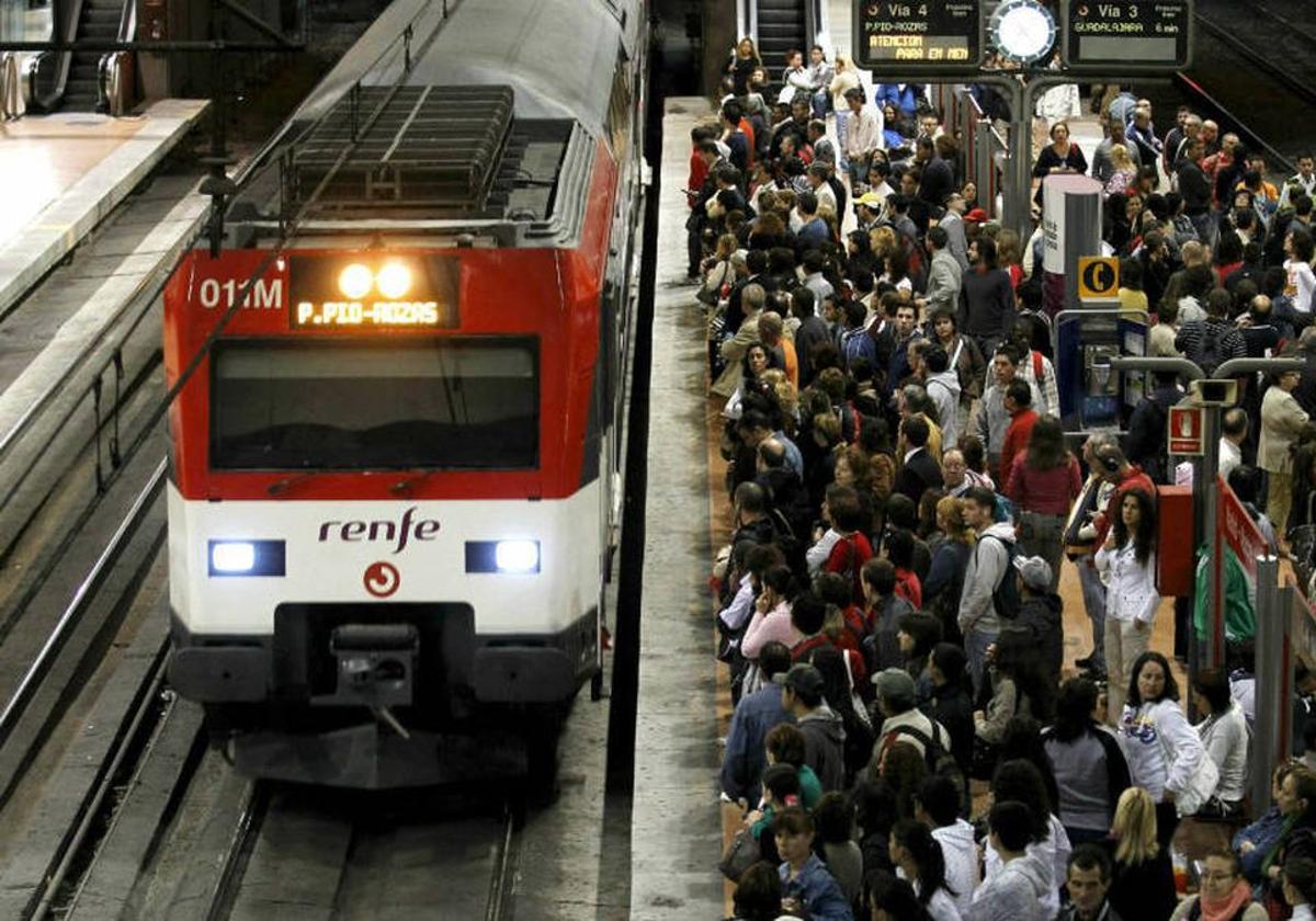 Decenas de viajeros esperan para tomar un tren de cercanías.