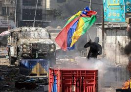 Un palestino se enfrenta con una sombrilla a uno de los blindados israelíes.