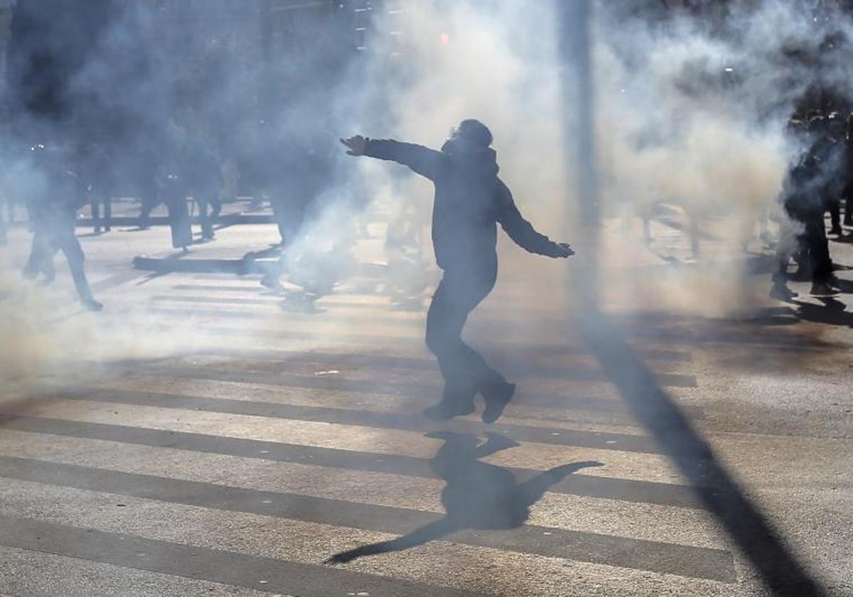 Un hombre arroja un objeto a la Policía antidisturbios durante los enfrentamientos registrados en Atenas frente a la sede del Parlamento.