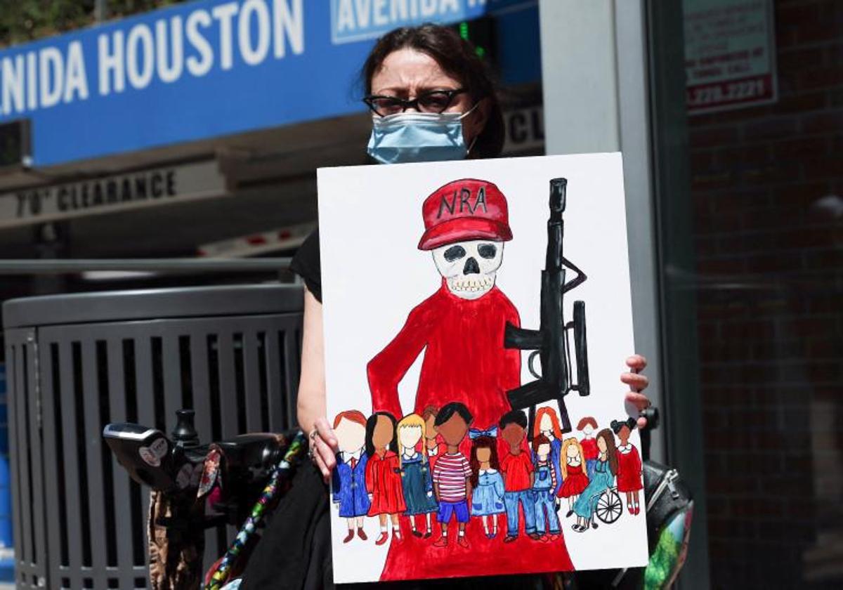 Una mujer sostiene un cartel contra las leyes de armas en Houston, Texas.