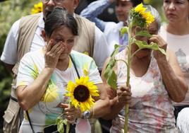 Dos mujeres participan en un homenaje a víctimas de desaparición forzada durante el conflicto armado en Colombia