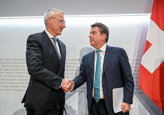 El presidente de UBS, Colm Kelleher (derecha), le da la mano al presidente de Credit Suisse, Axel Lehmann.