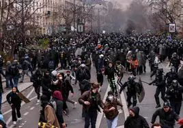 Decenas de manifestantes corren delante de la Policía francesa en París durante una nueva jornada de protestas contra la reforma de las pensiones.