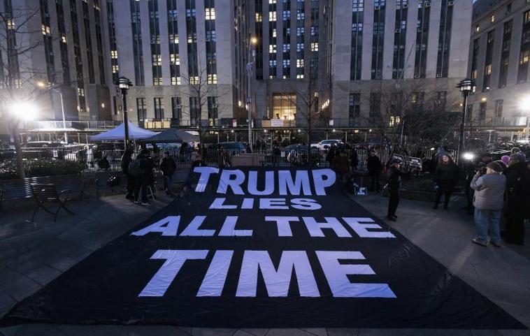 Opositores al expresidente desplegaron anoche una pancarta frente a la sede judicial con la frase 'Trump miente todo el tiempo'