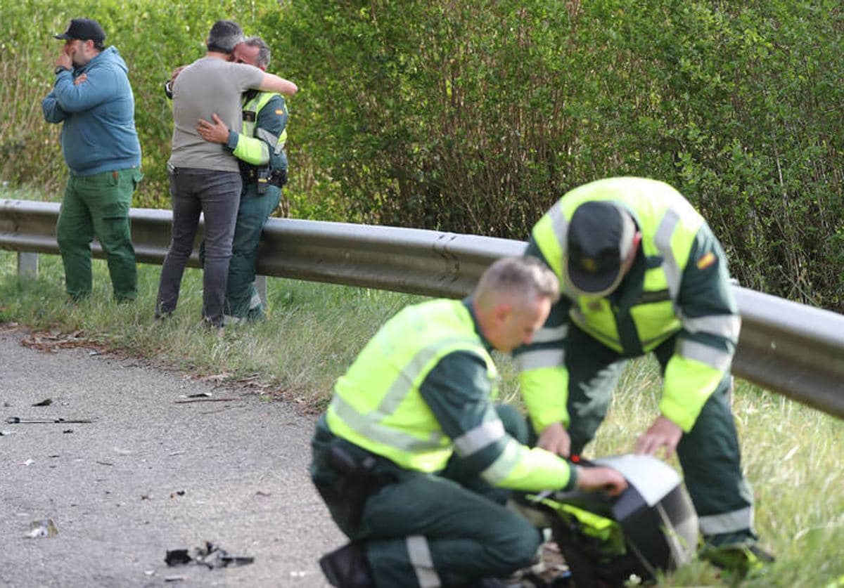 Dos guardias civiles revisan los restos de la moto oficial que estaba junto a su compañero mortalmente atropellado.