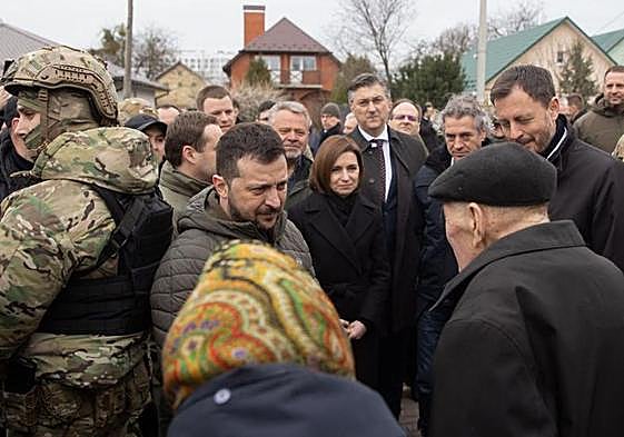 Volodímir Zelenski habla con residentes en Bucha durante el homenaje del viernes con motivo del aniversario de la masacre.
