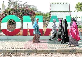 Mujeres caminan junto a un cartel turístico en la ciudad de Hargeisa, en Somaliland.