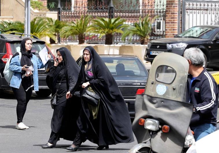 Dos mujeres iraníes caminan en una calle de Teherán