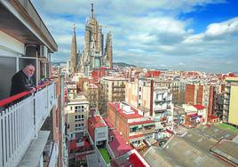 Un vecino observa desde su balcón el avance de las obras, que podrían a obligar a expropiar dos manzanas del Eixample barcelonés.