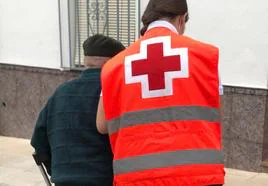 Un voluntario de Cruz Roja ayuda a una persona mayor.