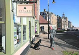 Un vecino pasea a su perro por una calle de Poundbury.