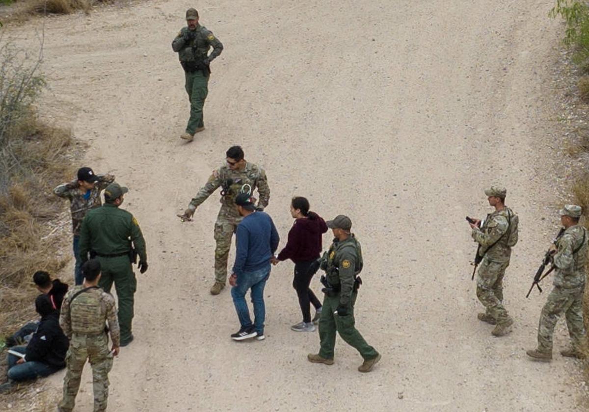 Agentes interceptan a migrantes que acababan de cruzar el río Bravo en su camino de México a Estados Unidos.