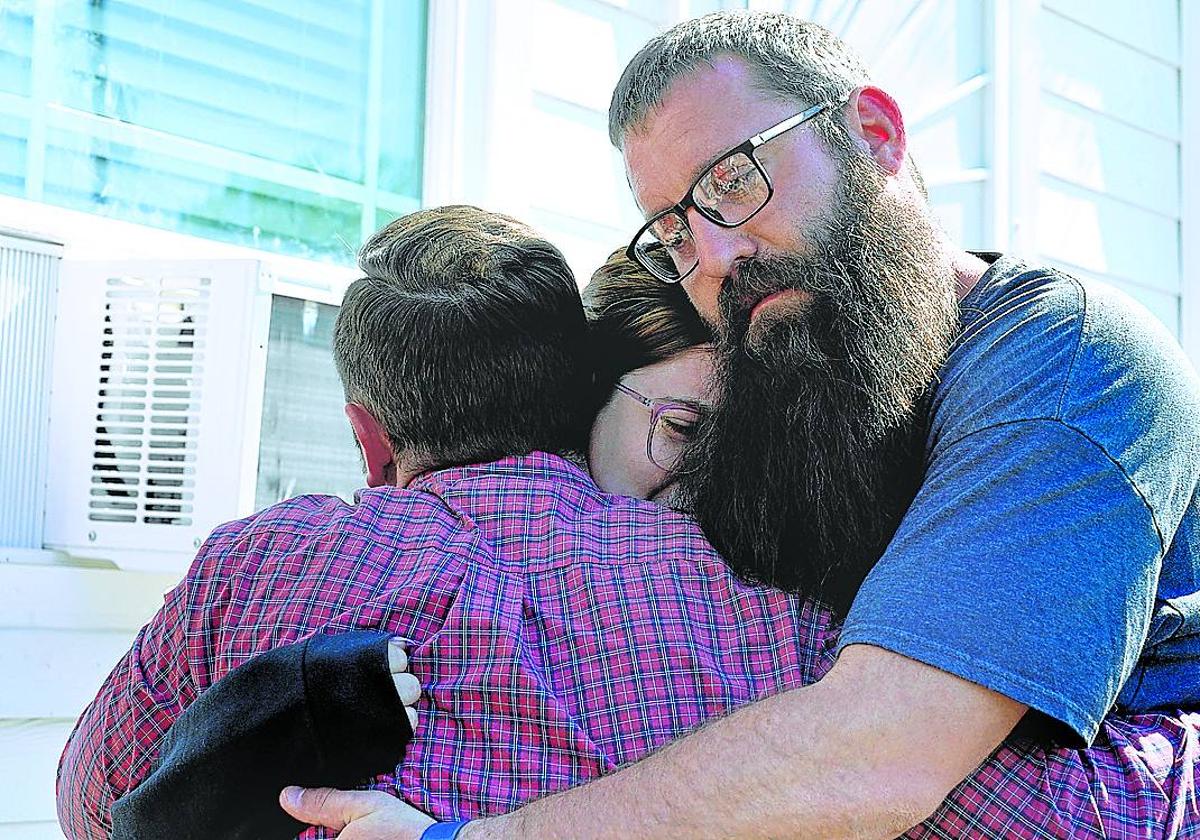 Un reportero abraza a los padres de una de las niñas asesinadas.