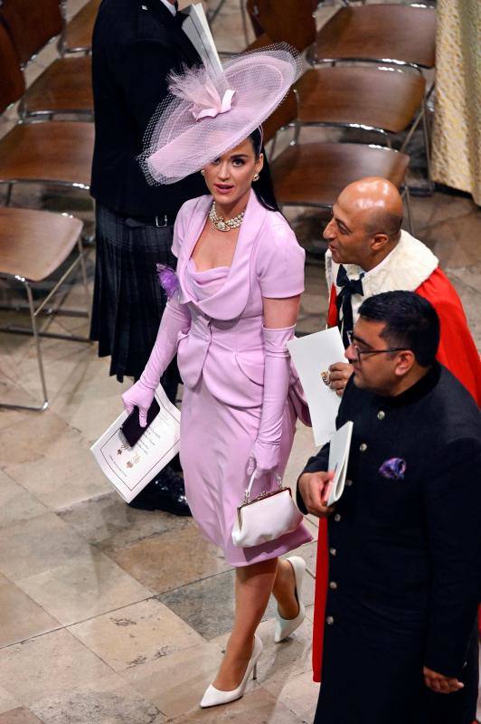 Kate Perry, con un traje dos piezas lila de la fallecida diseñadora Vivienne Westwood y un llamativo tocado. La cantante actuará mañana en el concierto con motivo de la coronación de Carlos III. 