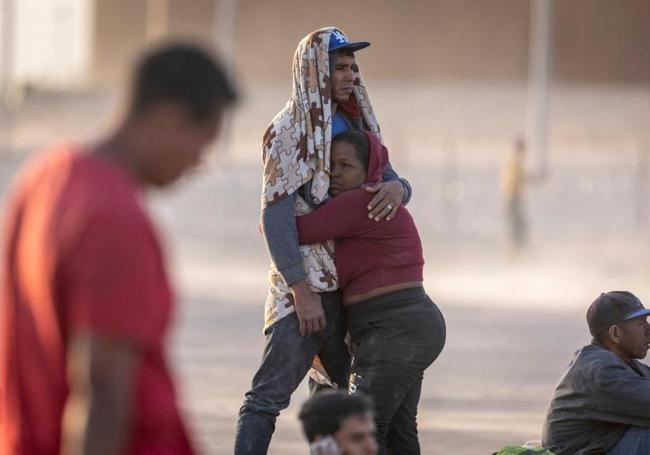 Una pareja de centroamericanos se abraza ante el paso fronterizo.