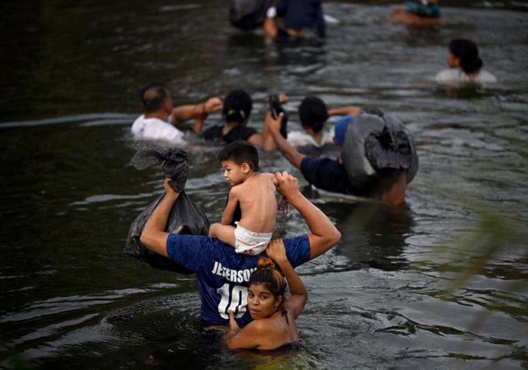 Un grupo de migrantes atraviesa el río Grande por Matamoros.