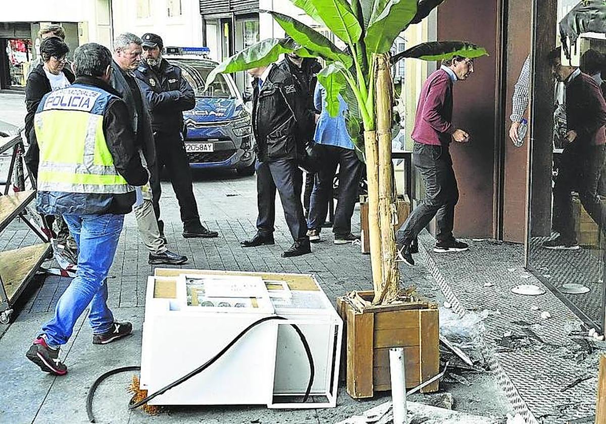 Vista del exterior de la pizzeria incendiada en Madrid el pasado 21 de abril el día después del suceso, cuando lo visitó el alcalde de Madrid, José Luis Martínez-Almeida (derecha).