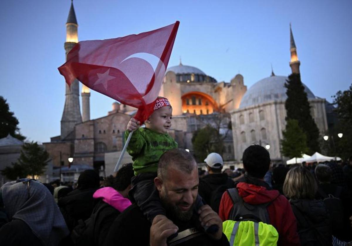 Un padre y su hijo exhiben una bandera turca en un acto electoral en Estambul.