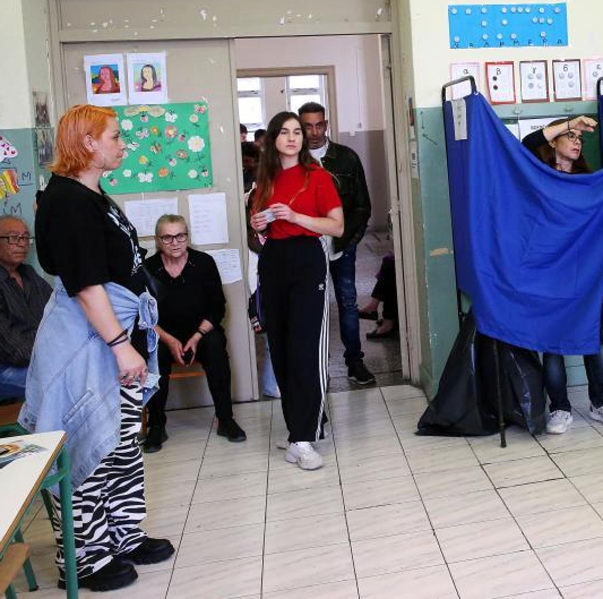 Electores de distintas generaciones se juntan en un colegio en los primeros comicios de la UE donde se permite votar a jóvenes de 17 años.