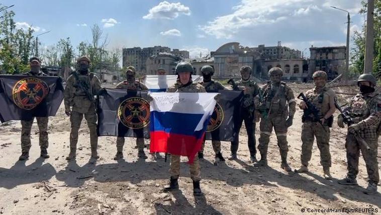 El jefe del Grupo Wagner y varios mercenarios posan con la bandera rusa y de su batallón en Bajmut