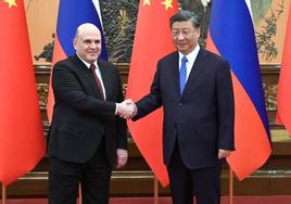 Mikhail Mishustin y Xi Jinping se saludan antes de su reunión en Pekín.