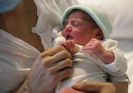 Imagen de una niña recién nacida junto a su madre, en la cama de un hospital de Zamora.